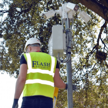 Man from FlashSecurity high-visibility vest and helmet installing a CCTV camera in London