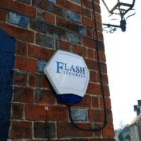 Flash Security Intruder Alarm on the brick wall