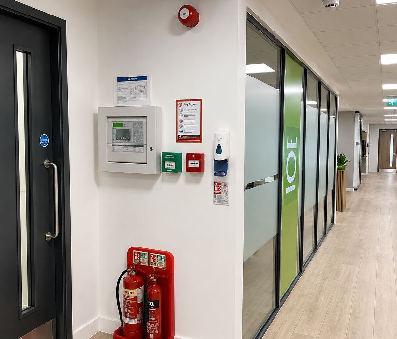 Engineer checking a fire alarm control panel during commercial fire alarm maintenance in Southwark